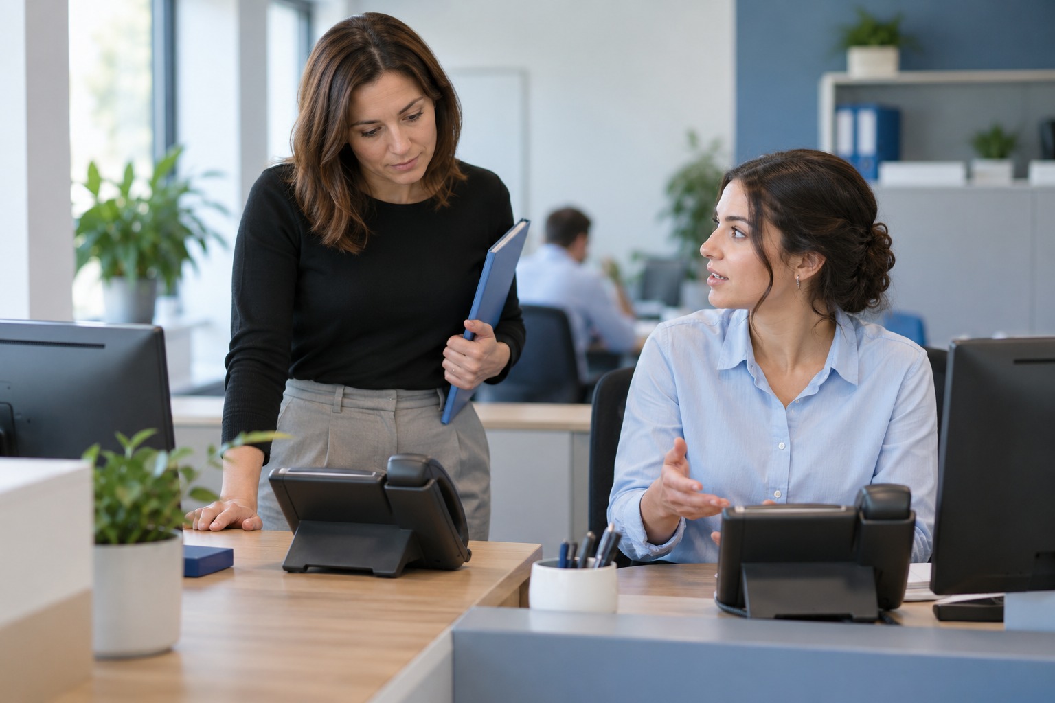 Colleagues discuss what they observed at two nearby office phones.